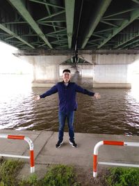 Portrait of young man standing on bridge