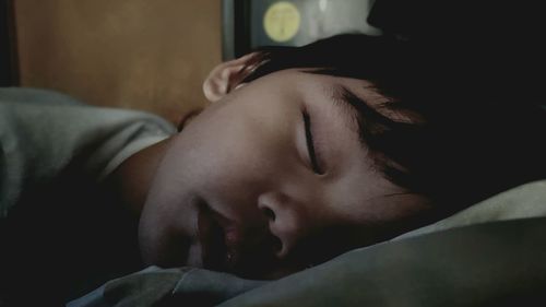 Close-up of boy sleeping on bed