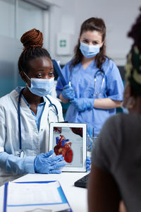 Female doctor examining patient in office