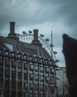 Low angle view of buildings against cloudy sky