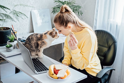 Freelancer young woman eating healthy food when working from home. woman eating healthy grain