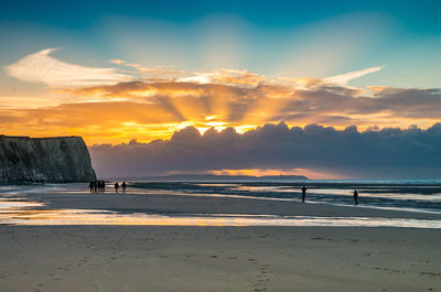 Scenic view of beach against sky during sunset