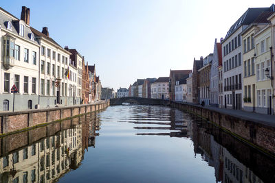 Canal amidst buildings against sky
