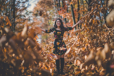 Full length of woman standing by tree