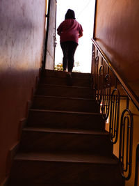 Rear view of woman standing on staircase