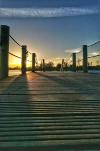 Illuminated suspension bridge against sky in city