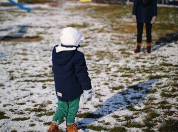 Rear view of a girl on snow covered beach