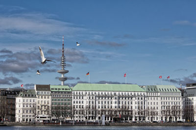 Buildings in city against cloudy sky