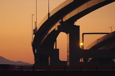 Silhouette bridge against sky during sunset