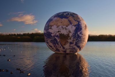 View over lake at dusk with floating globe