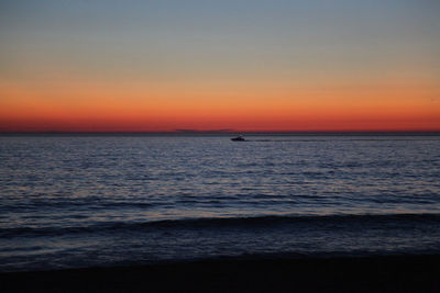 Scenic view of sea against orange sky