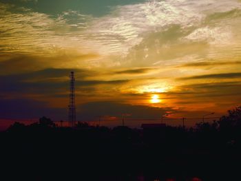 Silhouette of tower against sky during sunset