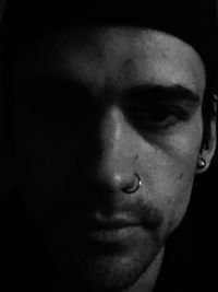 Close-up portrait of man against black background