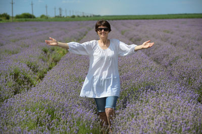 Happy middle aged woman walking in lavender field