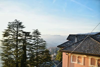 High section of building and trees against sky