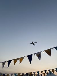 Low angle view of airplane flying against clear sky