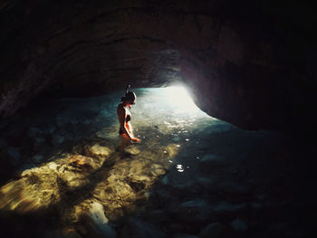 Full length of woman on rock in sea