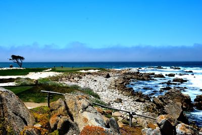 Scenic view of beach against blue sky