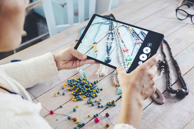 Midsection of woman using digital tablet