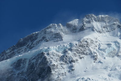 Scenic view of snowcapped mountains against clear blue sky