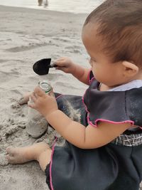 Baby girl playing sandbeach with plastic bottles