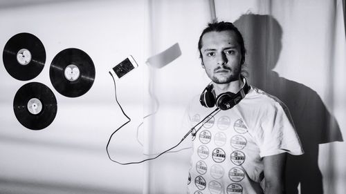 Portrait of young man standing against wall