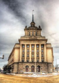 Facade of building against cloudy sky