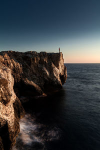 Rock formations by sea against sky