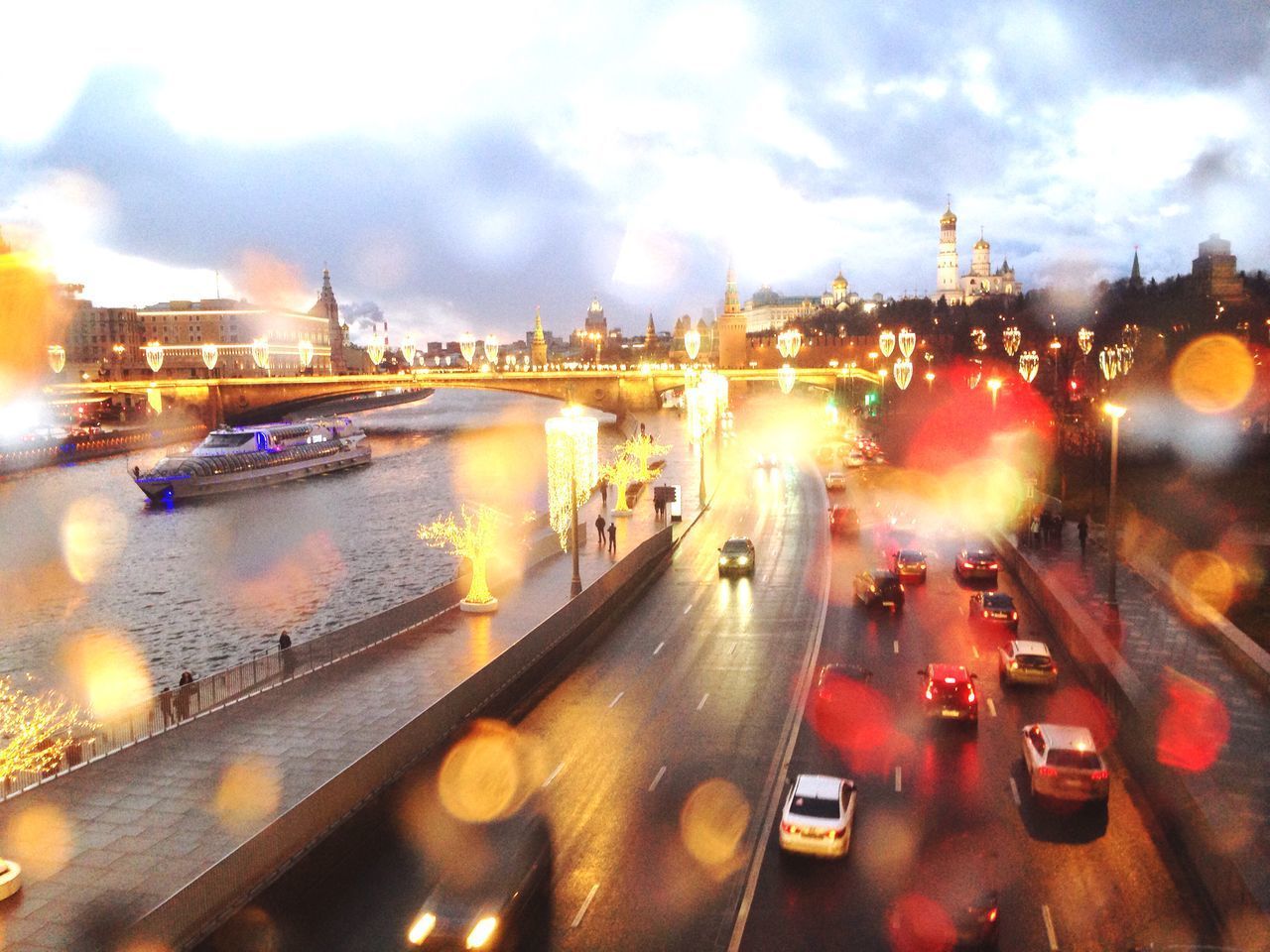 CARS ON ILLUMINATED BRIDGE IN CITY AT NIGHT