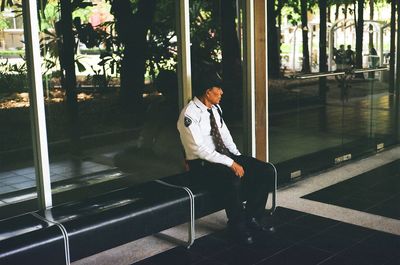 Man looking away while sitting on bench