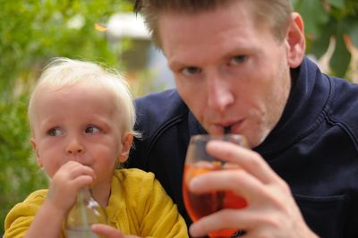 Close-up of father and son having drinks outdoors