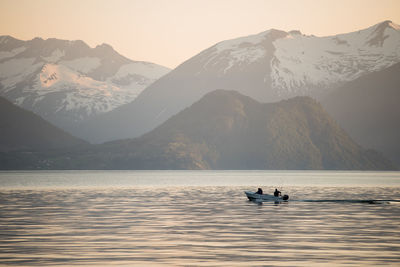 Scenic view of lake by mountains against sky