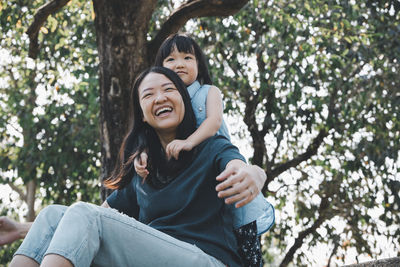 Portrait of a smiling young woman against trees