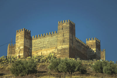 Low angle view of castle against clear blue sky