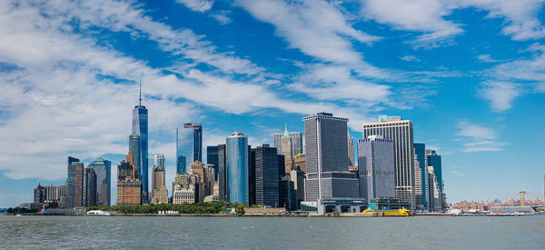 City at waterfront against cloudy sky