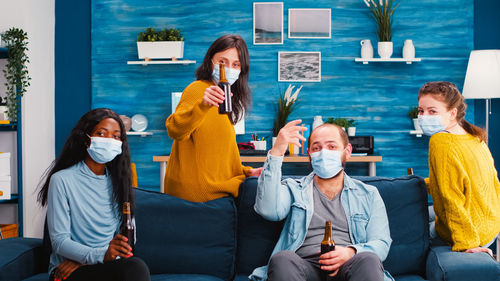 Portrait of people holding beer bottle at home