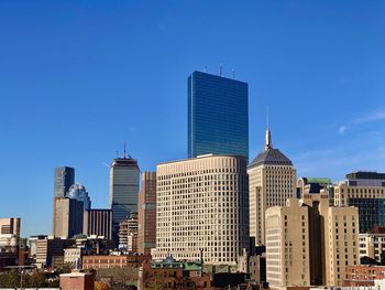 Modern buildings in city against clear blue sky