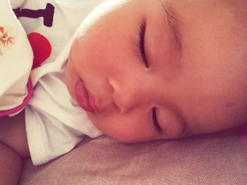 Close-up of baby sleeping on bed