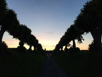 Silhouette trees on landscape against clear sky