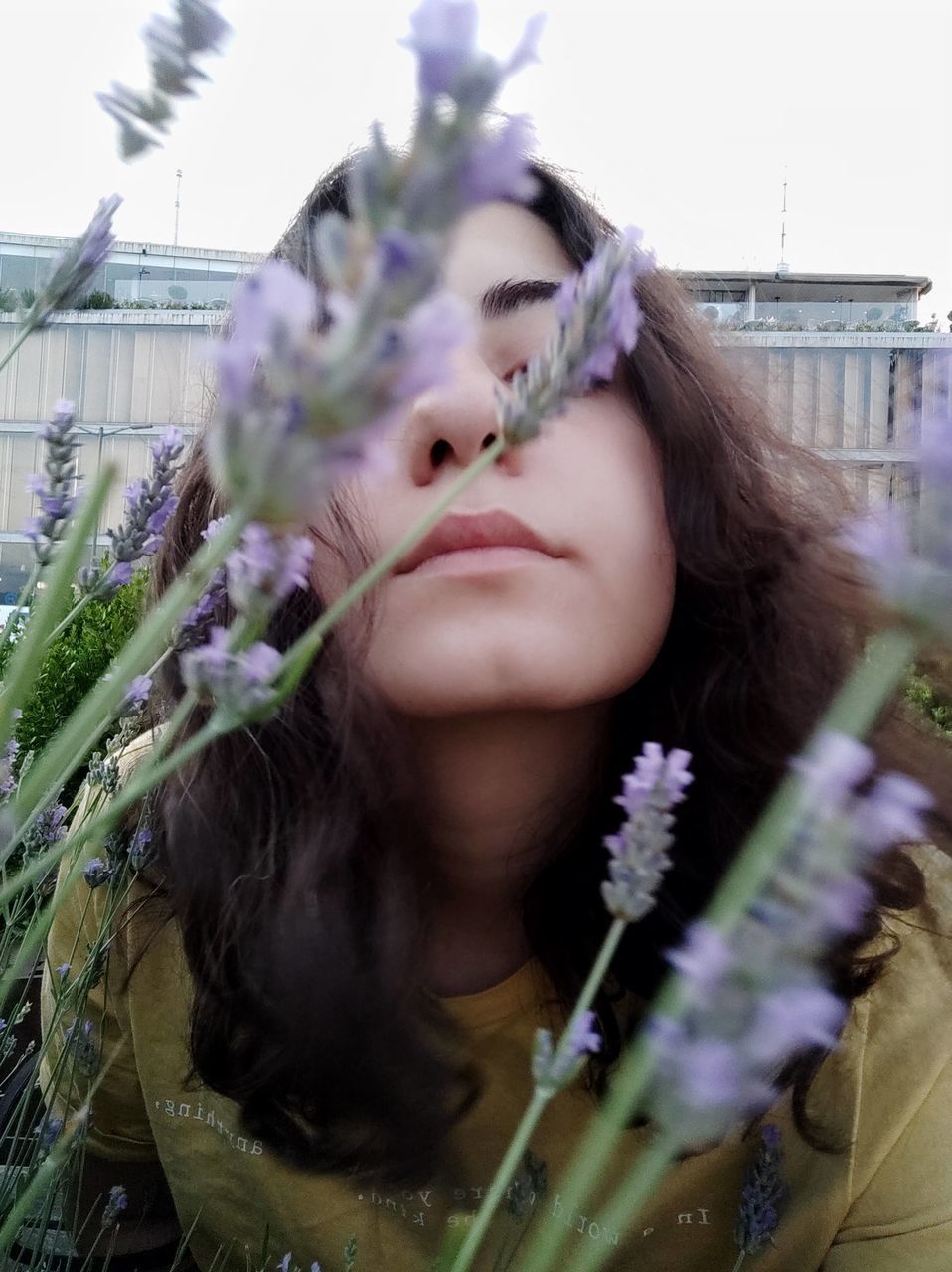 PORTRAIT OF WOMAN WITH PINK FLOWERS IN MOUTH OPEN