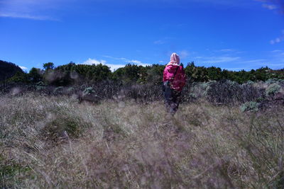 Woman standing on field against sky