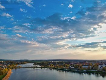 Scenic view of river by buildings against sky