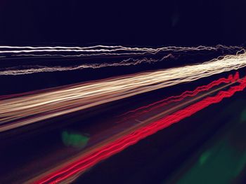 Light trails on street against sky at night