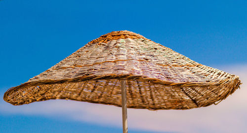 Low angle view of parasol against clear blue sky