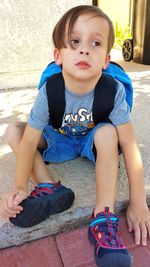 Portrait of cute boy sitting on floor