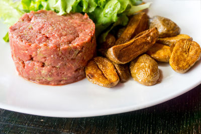 Close-up of beef with prepared potatoes served in plate