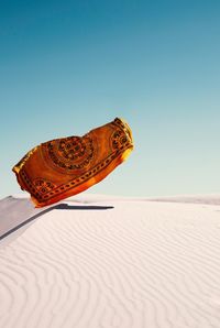 Blanket in mid-air blanket over desert against sky