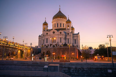 Illuminated building against sky in city