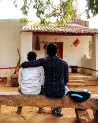 Rear view of man and woman against building