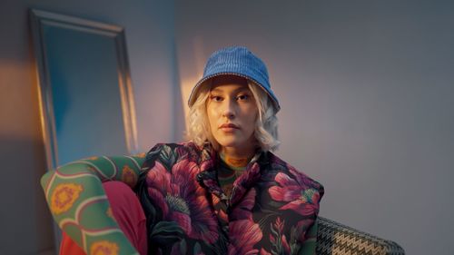 Portrait of young woman sitting on sofa at home